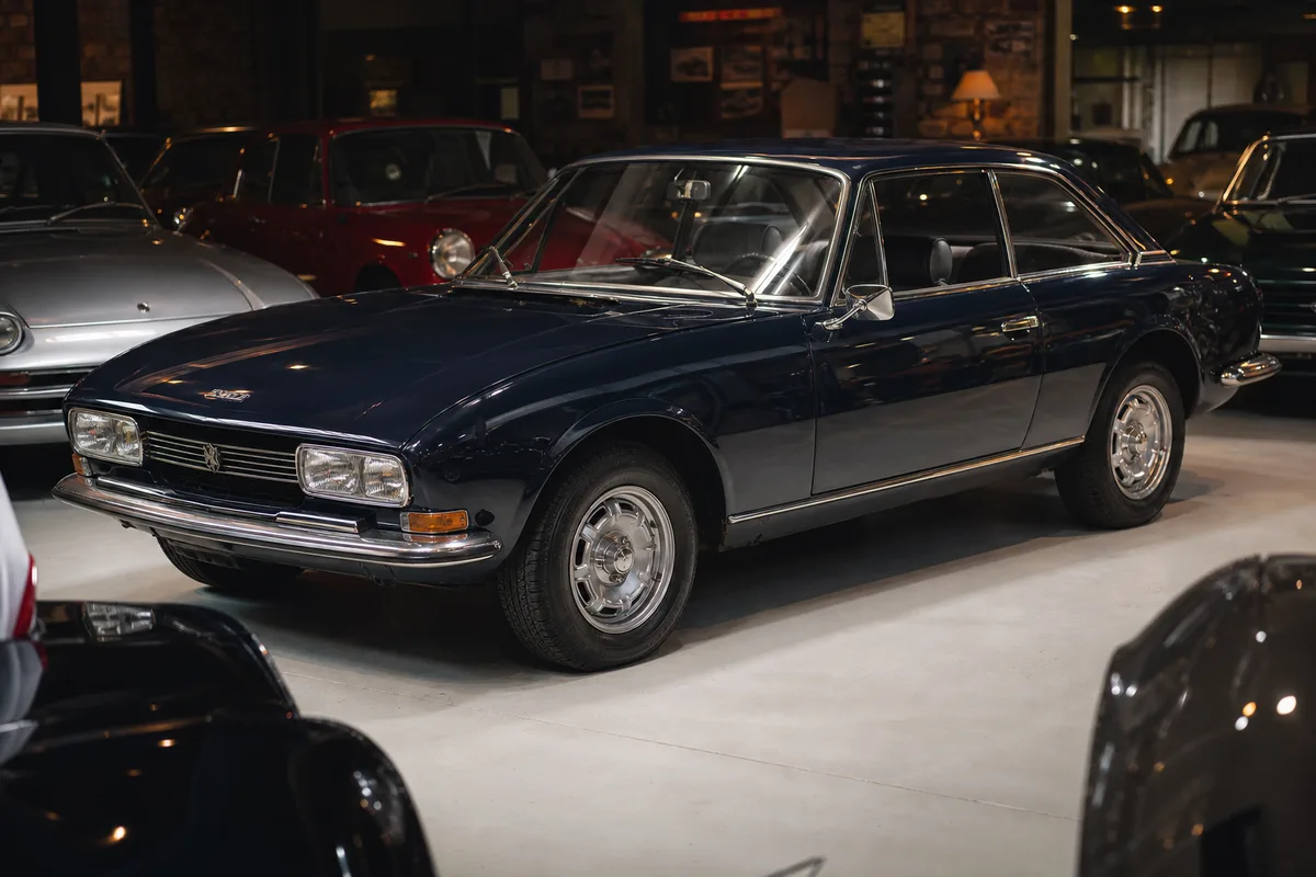 Coupé Peugeot 504 bleu nuit exposé lors d&rsquo;un rassemblement de véhicules anciens